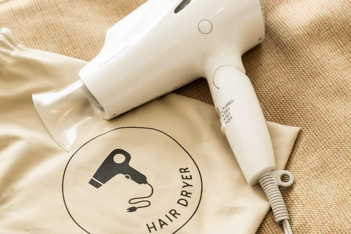 A hair dryer and a beige cloth with a logo and text.