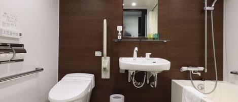 A modern bathroom with a toilet, sink, and bathtub.