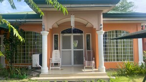 A building with a porch, a gated entrance, and a small garden area. - Villa 301 B&B (Baclayon)
