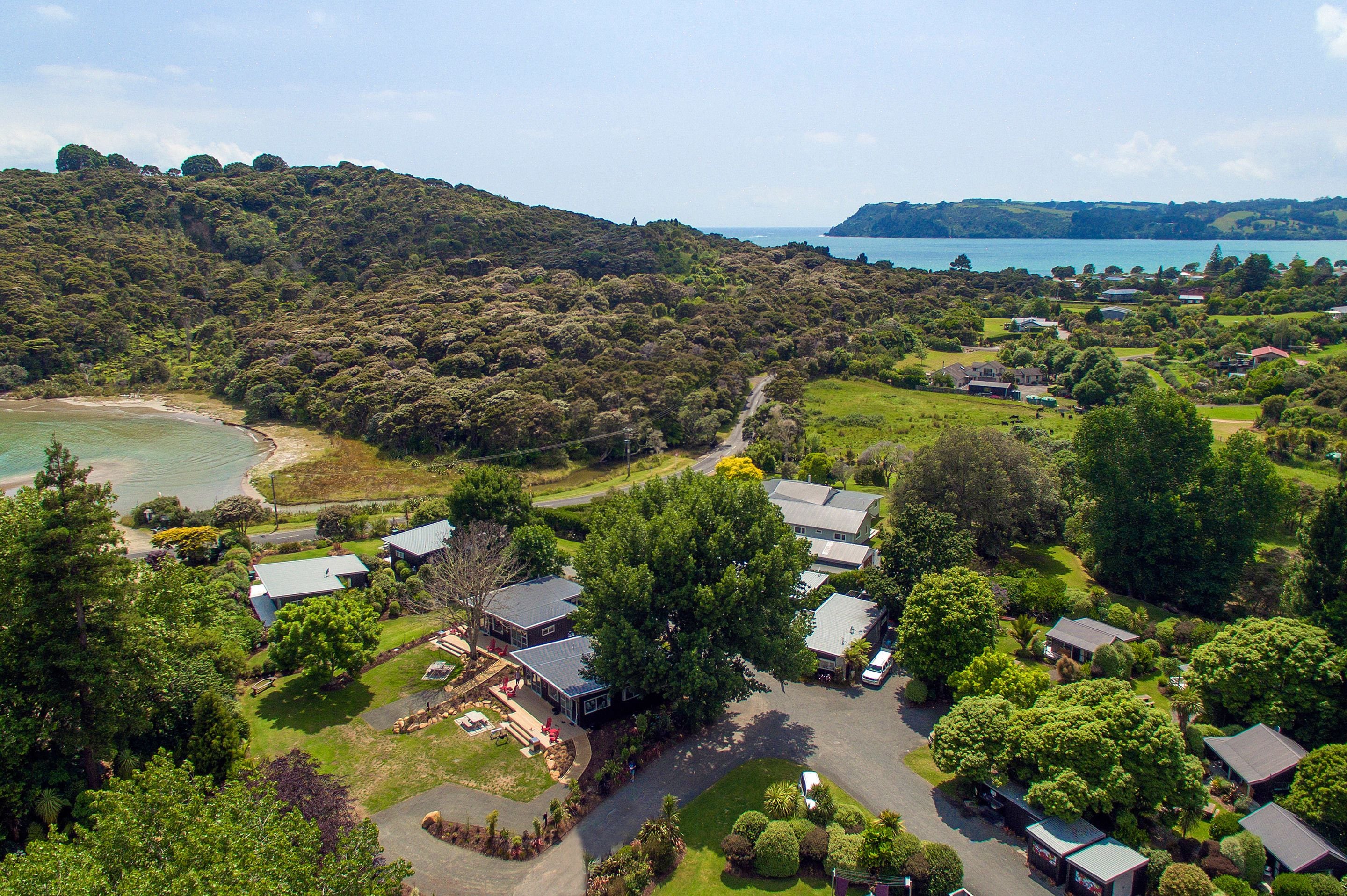 An aerial view of a resort with multiple buildings, a beach, and a lake.