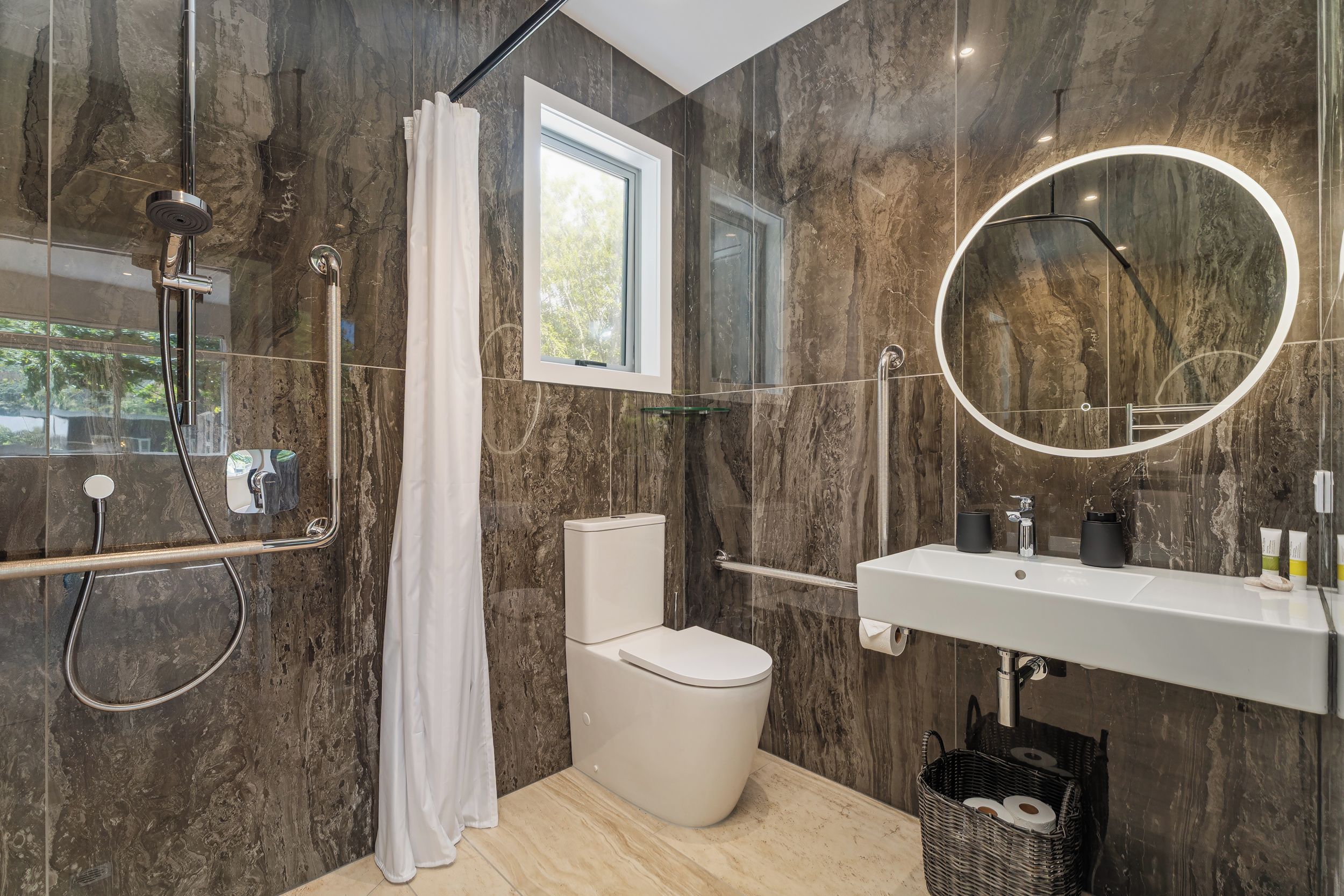 Une salle de bain moderne équipée d’une douche, de toilettes et d’un lavabo.