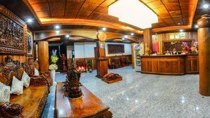 Un hall d’entrée avec un comptoir de réception, une grande horloge et des meubles en bois richement décorés.