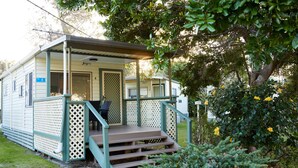 A small, single-story mobile home with a porch, a door labeled "Jayco," and a number "4" sign.