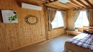 Une pièce de style cabane en bois, avec un lit, un calendrier, un miroir et des rideaux.