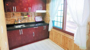 Une cuisine avec des meubles en bois, une fenêtre donnant sur un beau paysage et un évier.