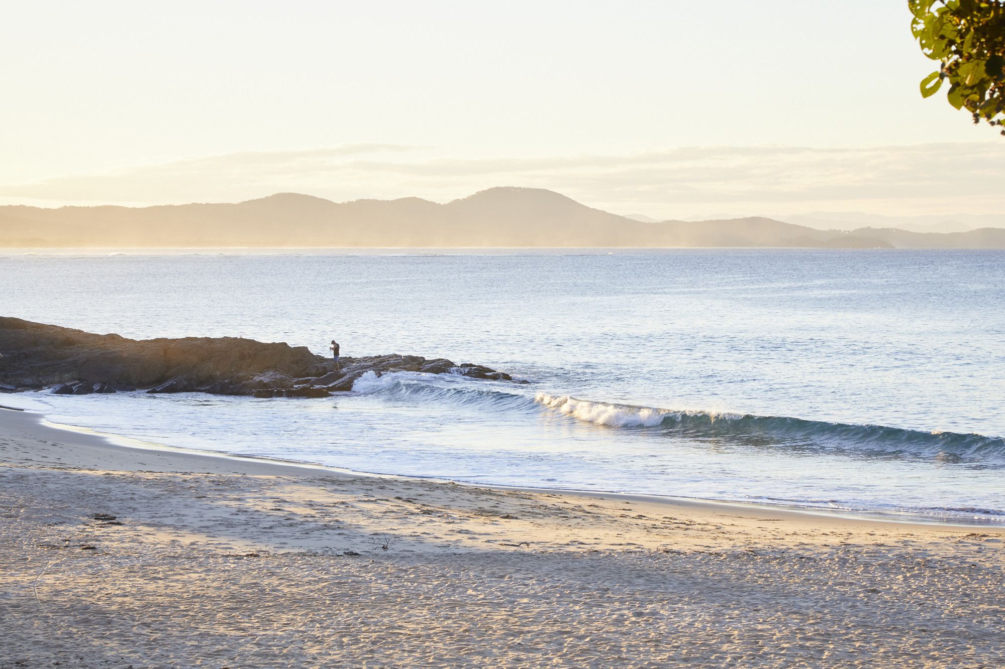A beach with a rocky shoreline and waves.