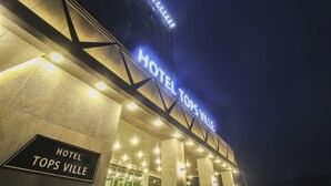 The exterior of Hotel Topsville at night with illuminated signage and a prominent entrance. - Hotel Tops Ville (Gangneung)