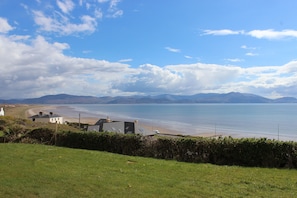 A coastal landscape with houses near the beach and a clear sky. - Luxury Beach View Cottage (Inch)