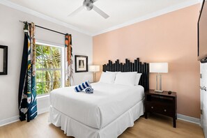 A hotel room with a bed, a ceiling fan, a nightstand with a lamp, and a window with curtains. - Dream Sunsets & Coastal Bliss–Beach Club 108A / RVA (Sarasota)