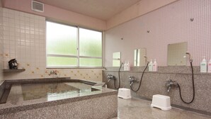 A bathroom with a large bathtub, a window, and a mirror.