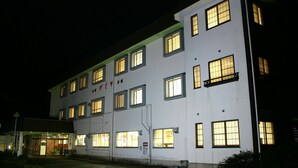 A multi-story building with illuminated windows and a sign in a foreign language.