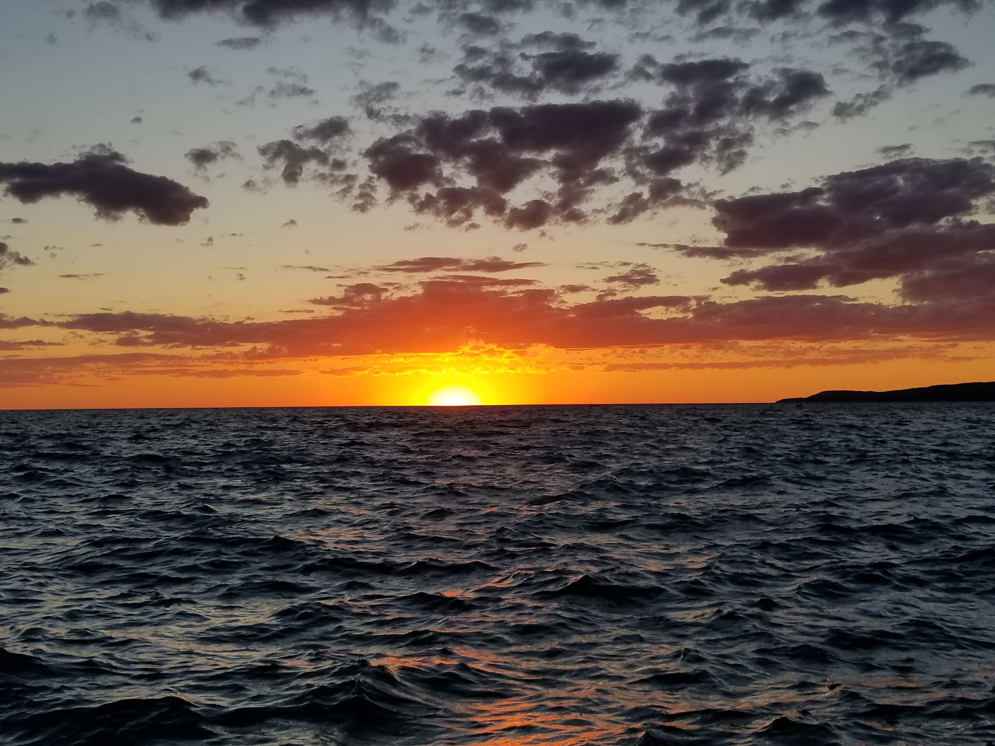 En solnedgång över havet med en klar himmel och utan synlig landmassa.