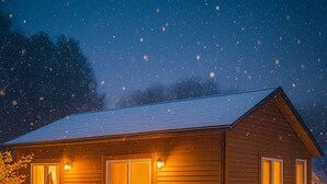 A wooden cabin with a porch, a covered outdoor seating area, and a snow-covered ground. - 3 blocks to the lake & close to downtown, high speed Internet, sleeps 6! (Boyne City)