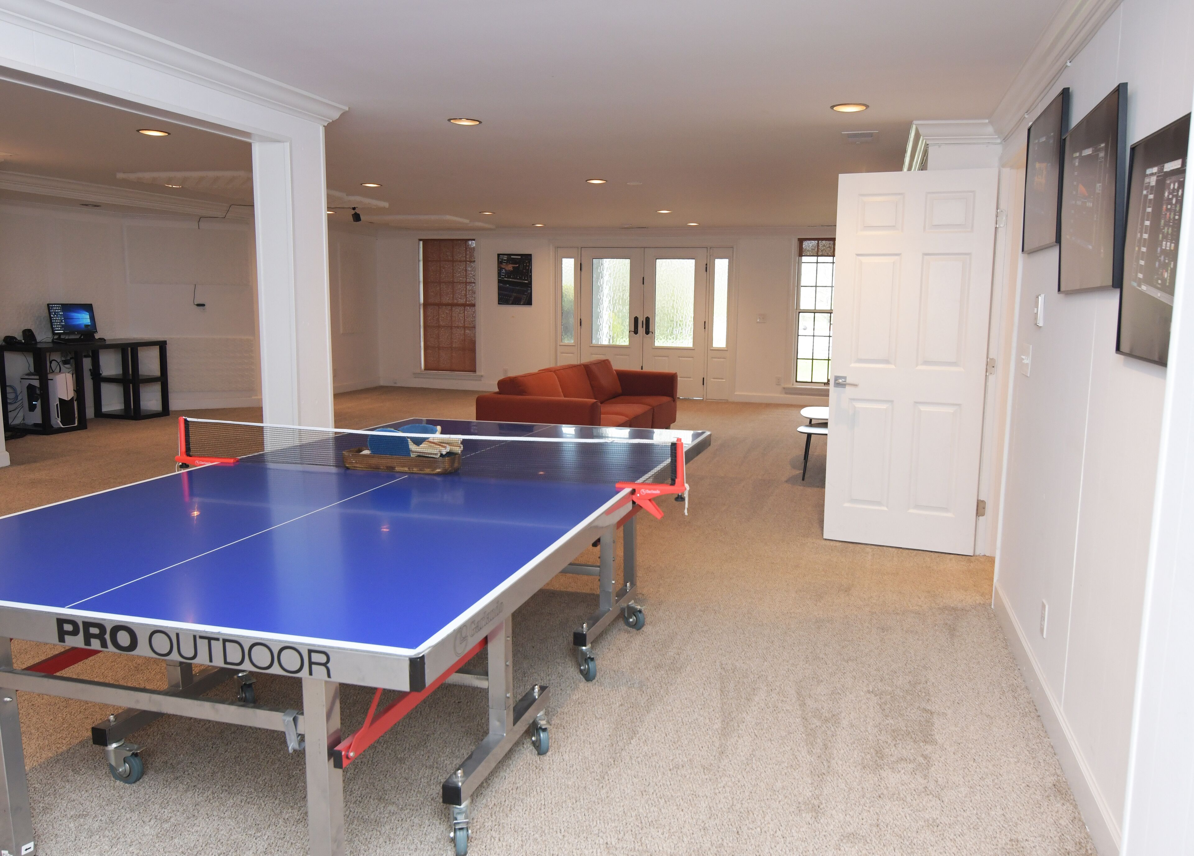 En rummelig stue med et ping-pong bord, en sofa og et lille bord.