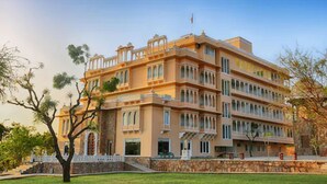 A multi-story building with a symmetrical facade, large windows, and a central entrance. - Fateh Niwas (Udaipur)