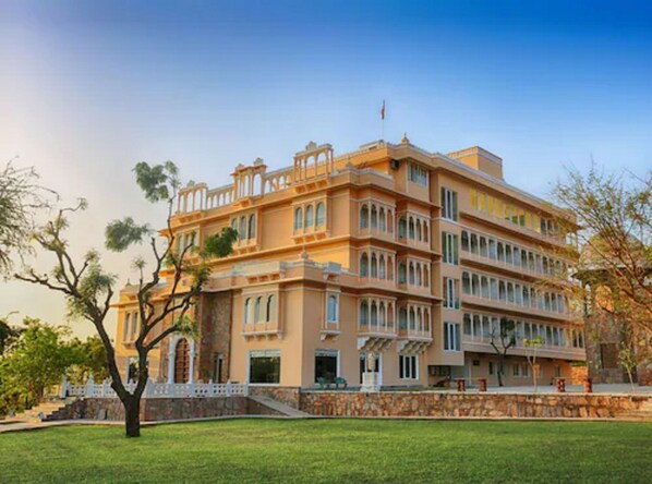 A multi-story building with a symmetrical facade, large windows, and a central entrance. - Fateh Niwas (Udaipur)