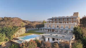 Un grand hôtel à plusieurs étages, doté d’une piscine, d’un espace extérieur aménagé et d’un jardin paysager.
