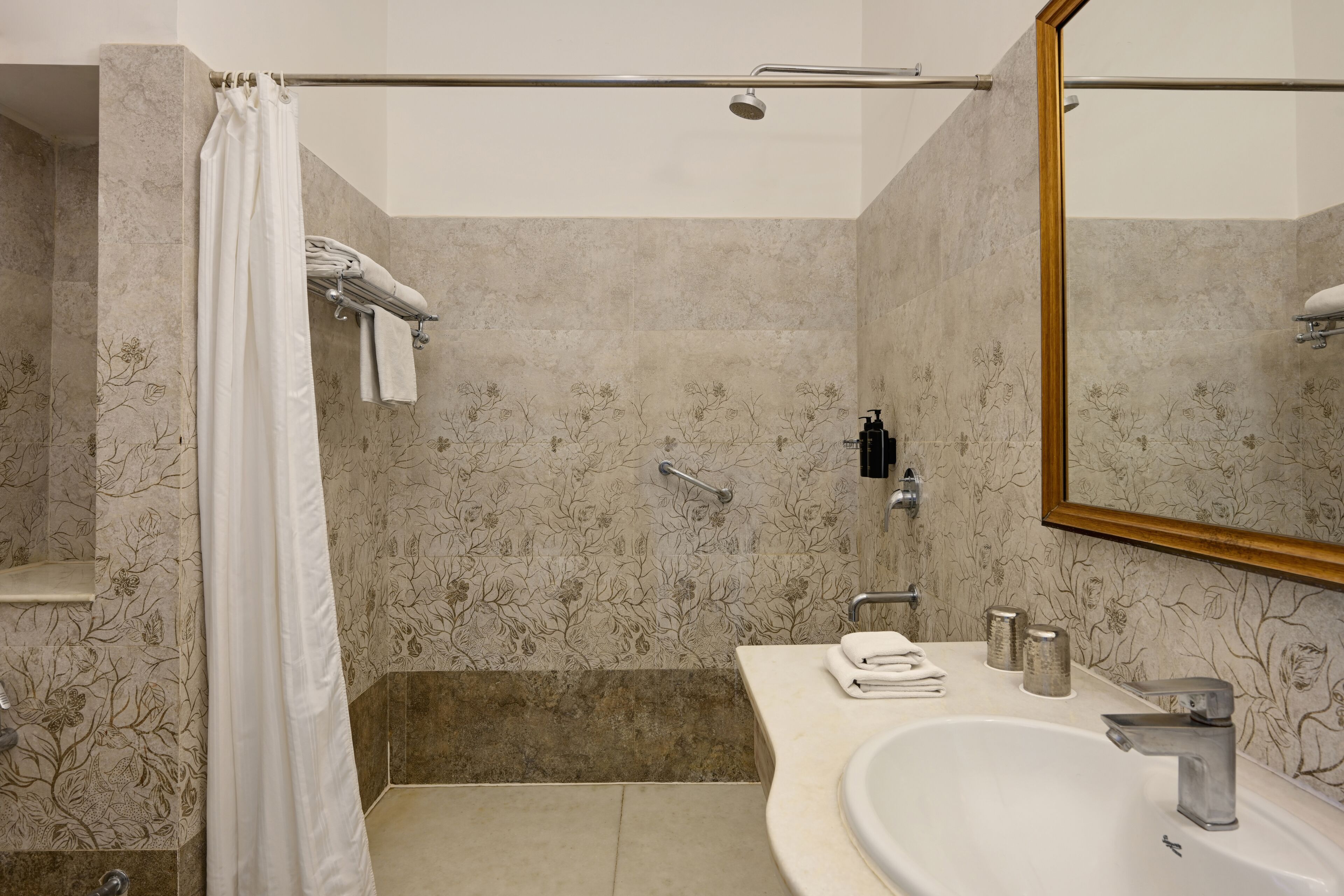 Un baño con ducha, lavabo y espejo.