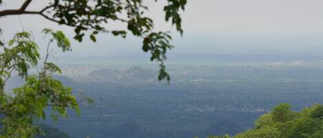 Vista panorámica de un paisaje montañoso con densa vegetación verde en primer plano.