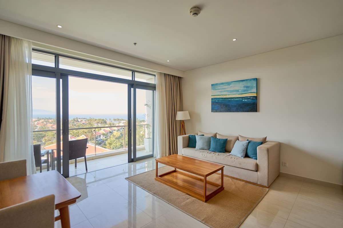 A modern living room with a sofa, coffee table, and dining table.