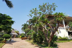 A residential area with a paved driveway leading to a house with a balcony. - Talekaew Resort (Phitsanulok)