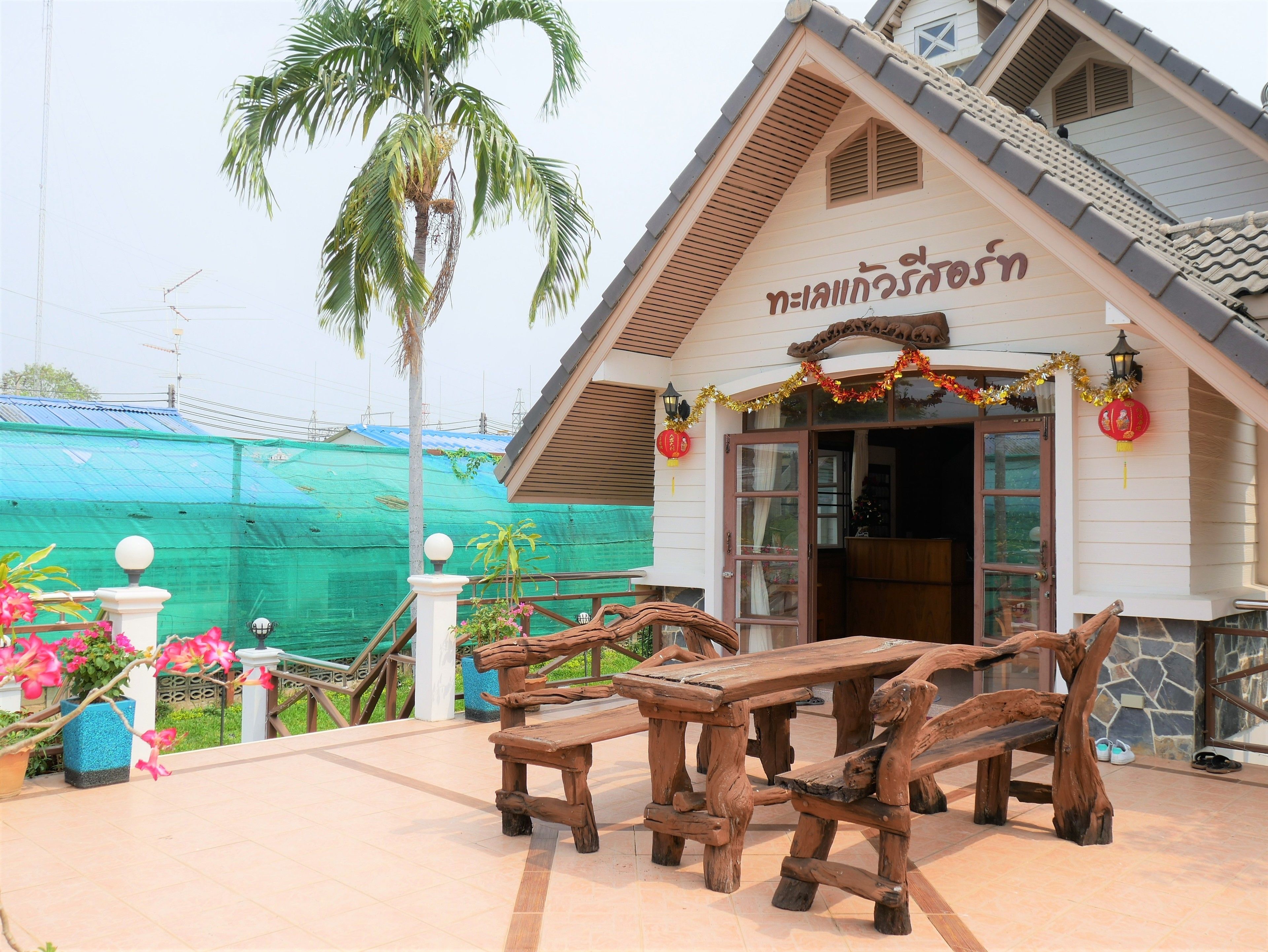 Un edificio tradizionale thailandese con un tavolo e panche in legno all'esterno.