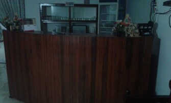A wooden reception desk with a glass display case behind it.