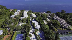 An aerial view of a coastal residential area with houses, a tennis court, and a swimming pool. - Gulf Getaway – Beach Castle #12 by RVA (Longboat Key)