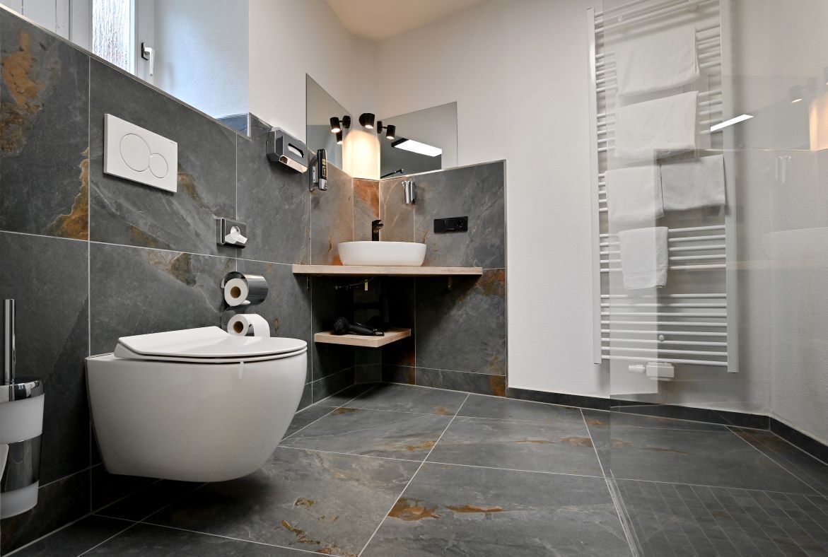 Une salle de bain moderne équipée de toilettes, d’un bidet et d’un lavabo.