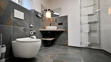 Une salle de bain moderne équipée de toilettes, d’un bidet et d’un lavabo.