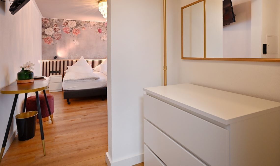 Ein Schlafzimmer mit Bett, Nachttisch und Kommode.