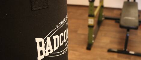A close-up of a boxing glove with the brand name "BADCO" visible.
