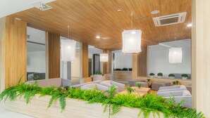 Een modern interieur met houten plafondpanelen, inbouwverlichting en een zithoek met banken en een salontafel.