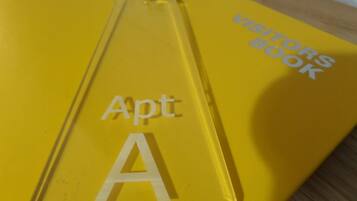 A yellow keychain with "Apt A" and "Visitors Book" text.
