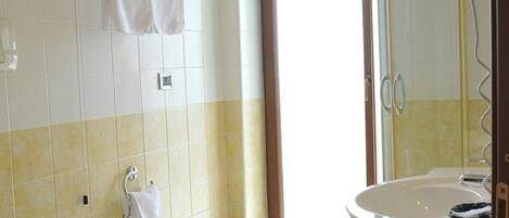 Un baño con dos inodoros, un bidé, un lavabo y un secador de pelo.