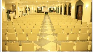Un salón de conferencias con filas de sillas orientadas hacia un escenario.