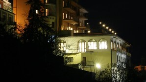 Un edificio de varios pisos con balcones y ventanas, iluminado durante la noche.