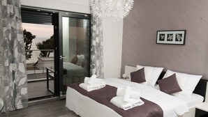 Un dormitorio moderno con una cama grande, un ventanal corredero que da a un balcón y un cuadro enmarcado en la pared.