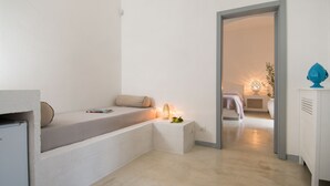 A minimalist bedroom with a built-in bed, bedside lamp, and a small bedside table. - Masseria Spesseto (Fasano)