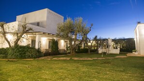 A modern building with a flat roof, a covered patio area, and a well-maintained lawn. - Masseria Spesseto (Fasano)