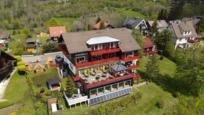 A multi-story hotel with outdoor seating and solar panels. - Harmonie Hotel Rust (Braunlage)