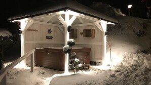 A snow-covered outdoor area with a wooden structure featuring a bench and a small table. - Harmonie Hotel Rust (Braunlage)