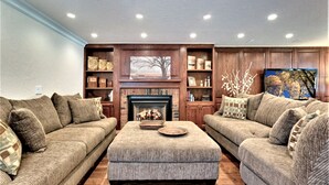 A living room with a fireplace, two sofas, a coffee table, and a television. - Zephyr Cove Versailles Private Beach & Ski Permitted DSTR1077P NV vacation House (Glenbrook)