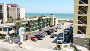 A multi-story hotel with a parking lot in front, a beach view, and a sign for 'SBA DUNNA'. - Myrtle Beach Villas 302A - 6 Bedroom Condo (Myrtle Beach)
