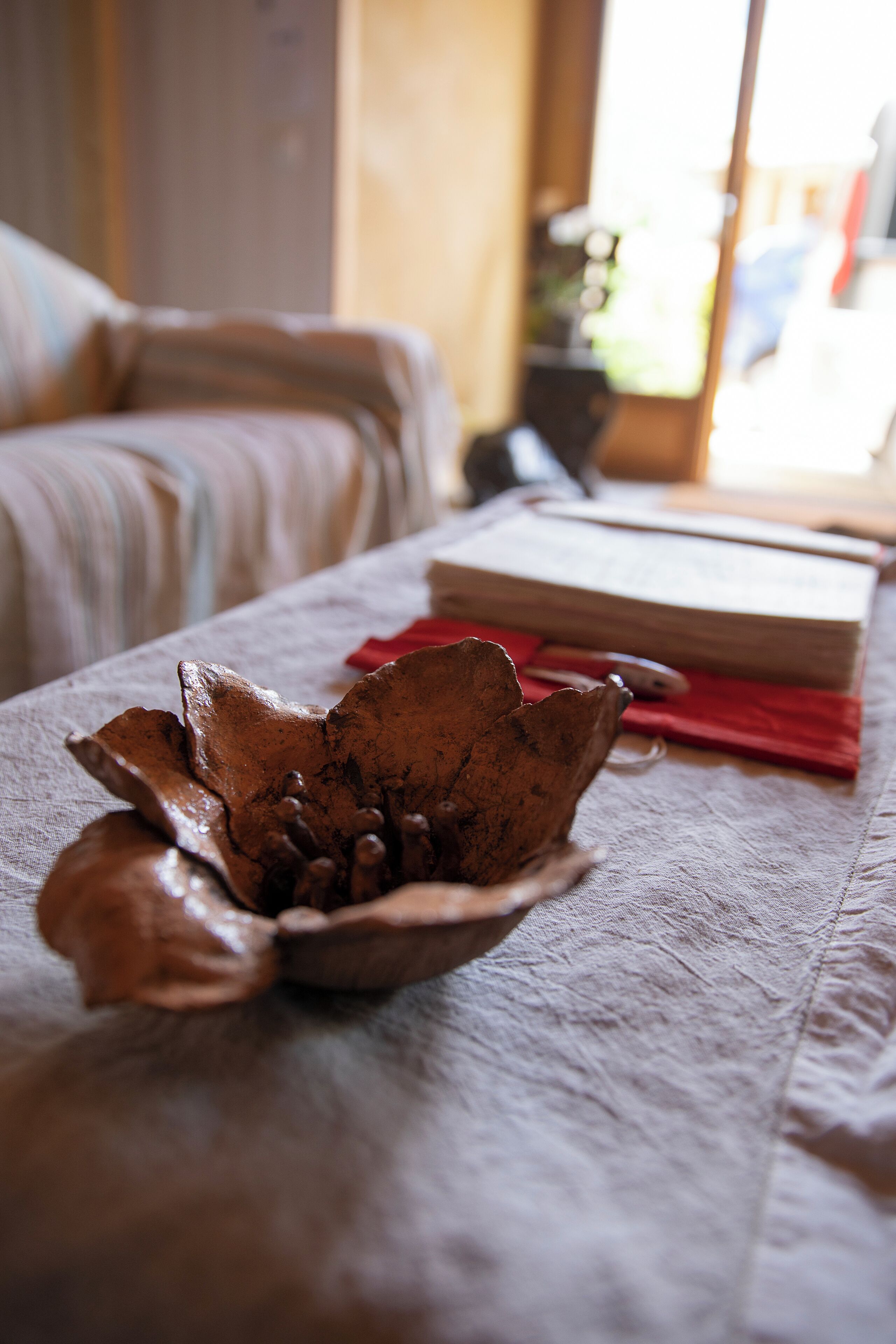 Un gros plan d’une surface de tissu texturé, avec un objet décoratif et un livre.
