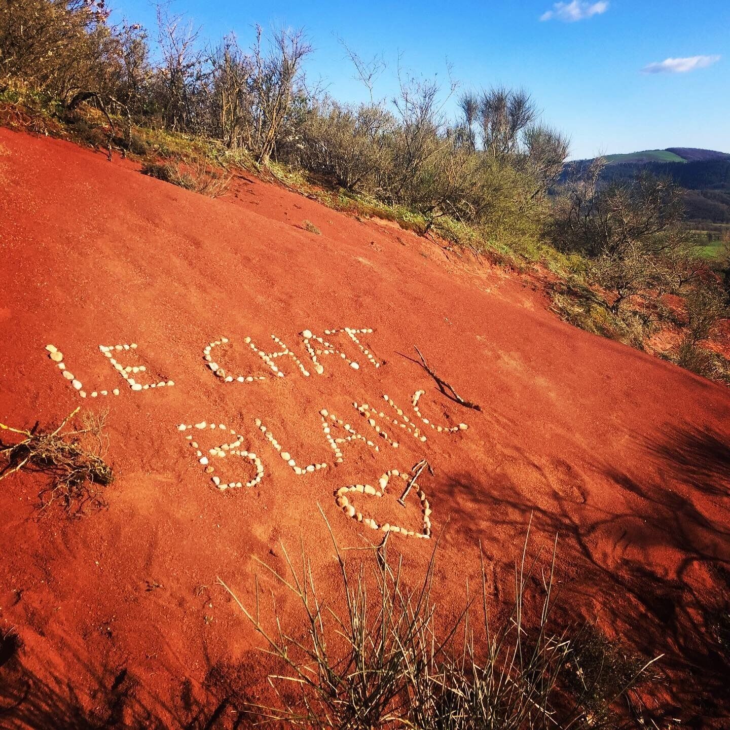 Un sendero de tierra roja con las palabras 