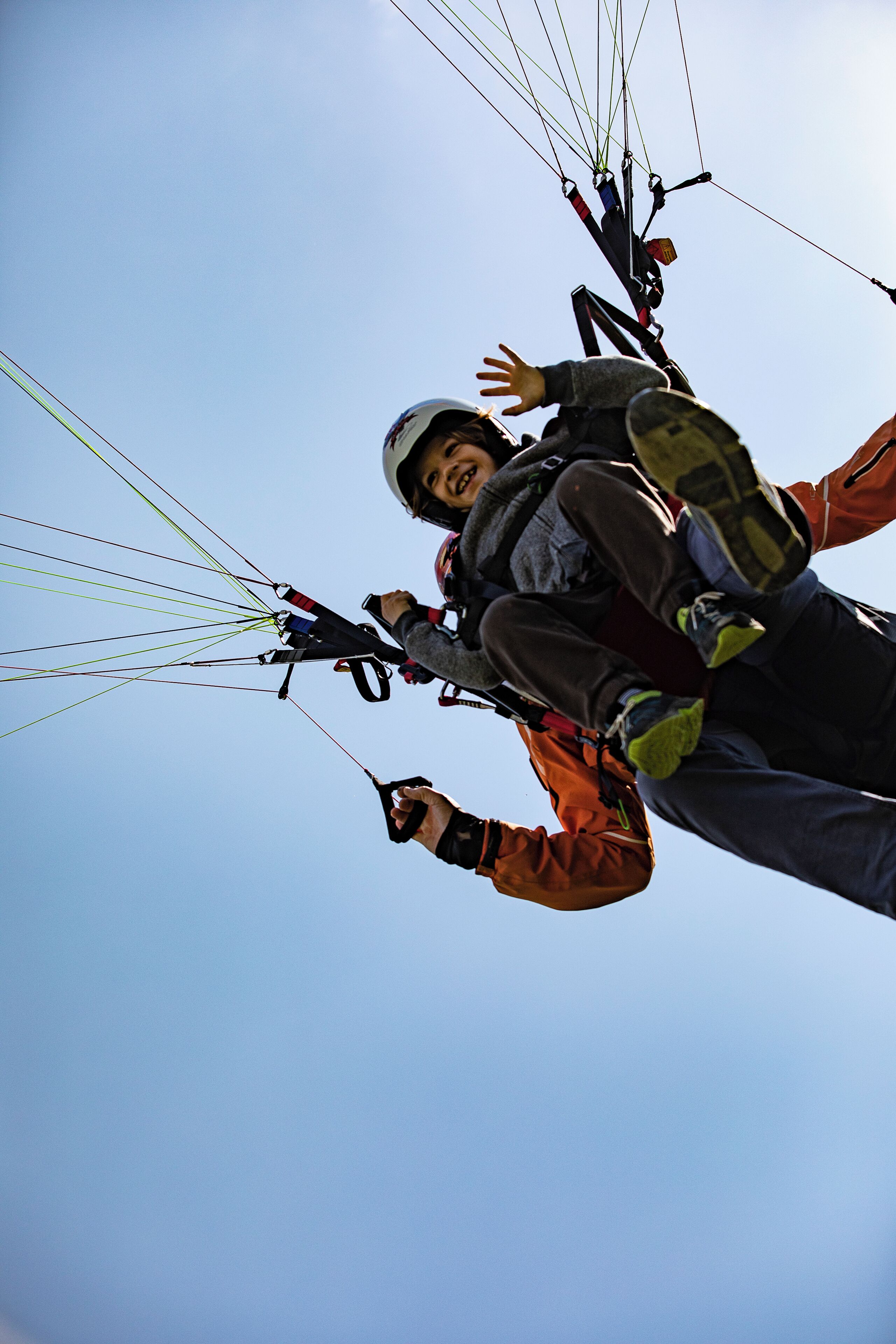 A person paragliding with a harness and parachute.