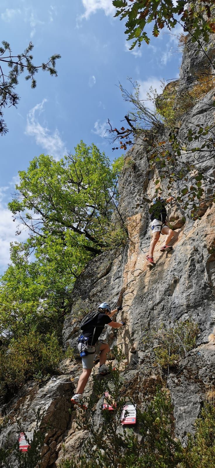Two individuals climbing a rocky mountain.