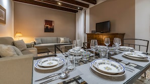 A dining area with a table set for four, surrounded by a sofa and a television. - San Moisé (Venice)