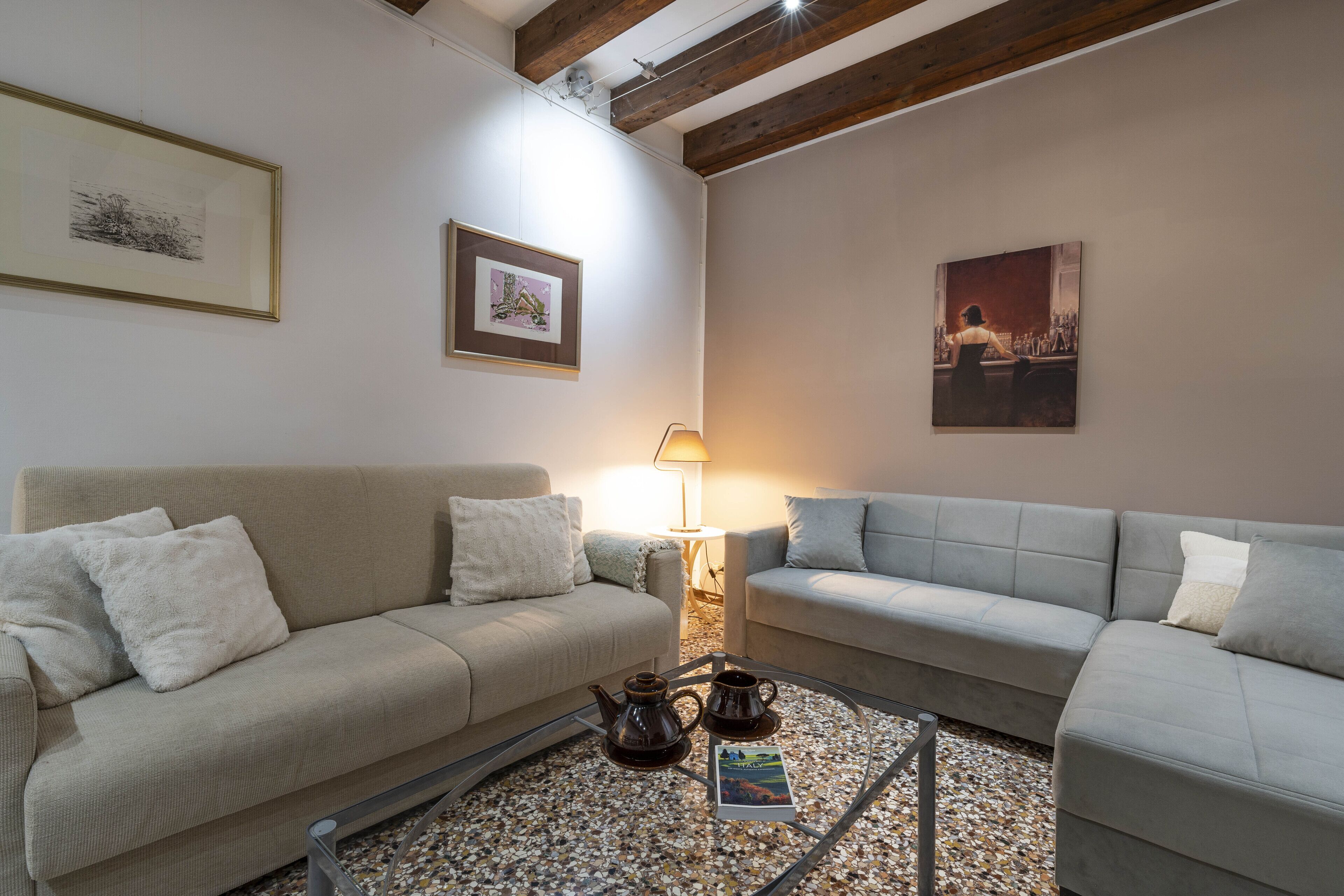 Uma sala de estar com dois sofás, uma mesa de centro e um abajur.